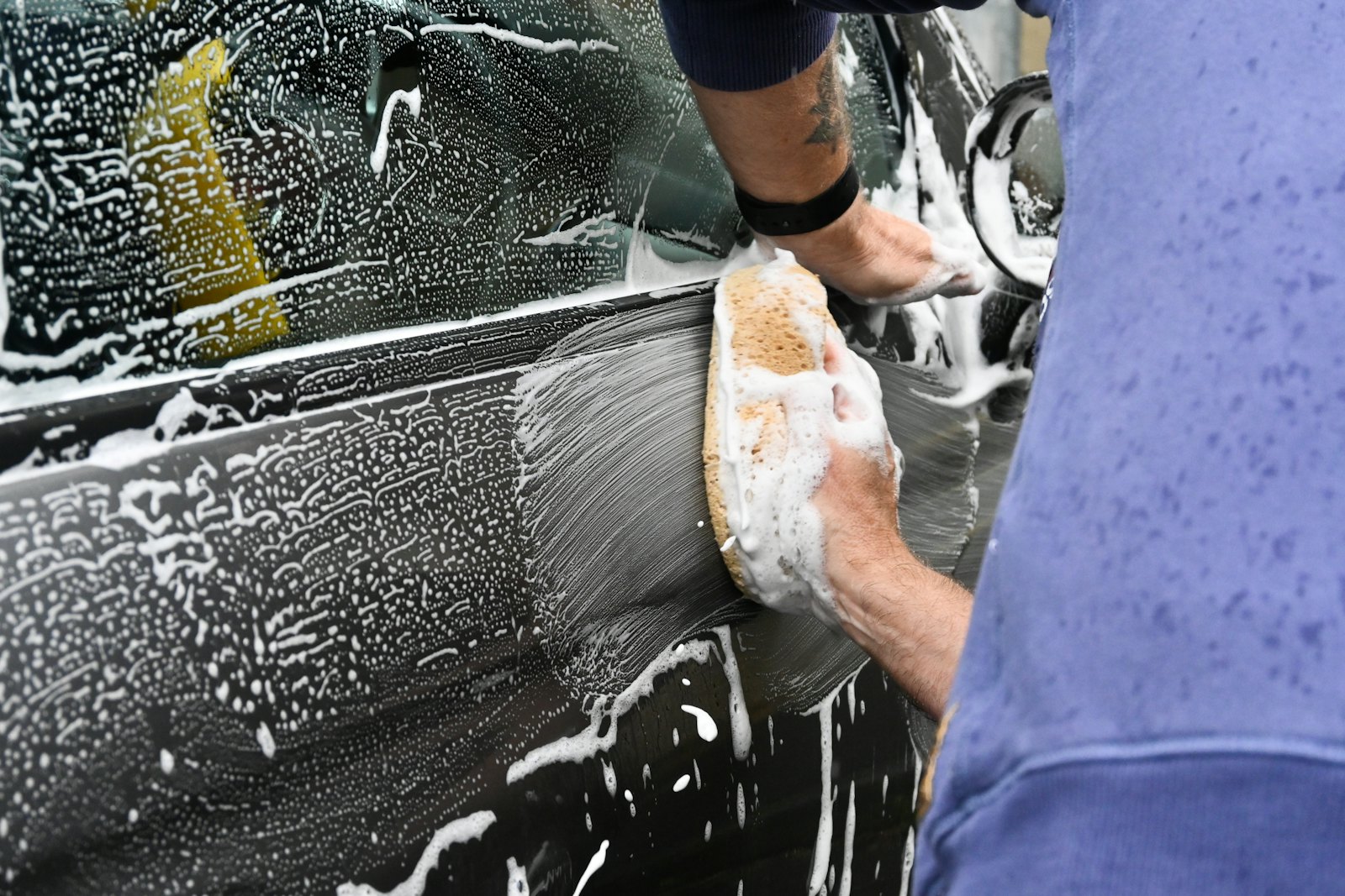 Detailer hand washing a car